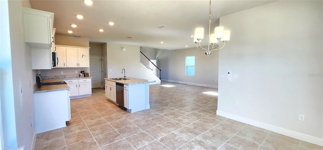 kitchen featuring stainless steel appliances, a notable chandelier, white cabinets, sink, and an island with sink