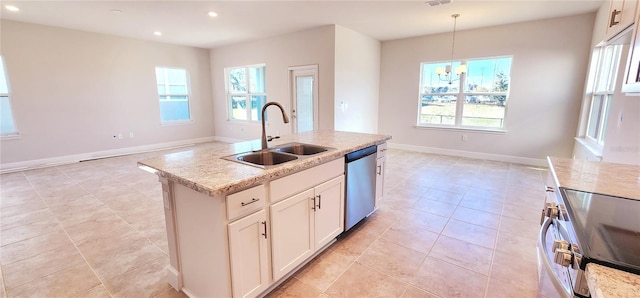 kitchen featuring decorative light fixtures, white cabinetry, stainless steel appliances, sink, and a kitchen island with sink