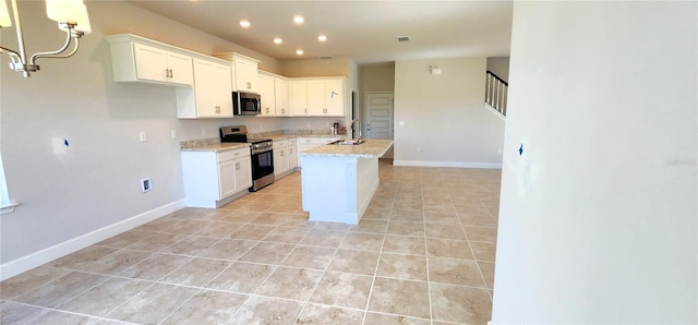 kitchen featuring light stone countertops, white cabinetry, a center island with sink, and stainless steel appliances