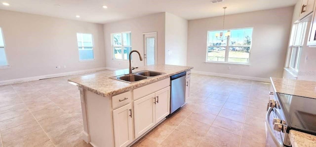 kitchen featuring pendant lighting, white cabinetry, stainless steel appliances, sink, and a kitchen island with sink