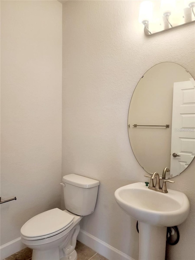 bathroom with sink, toilet, and tile patterned flooring