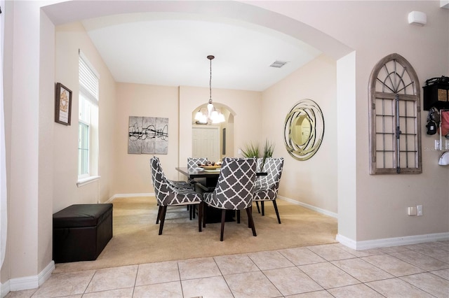 tiled dining room with an inviting chandelier