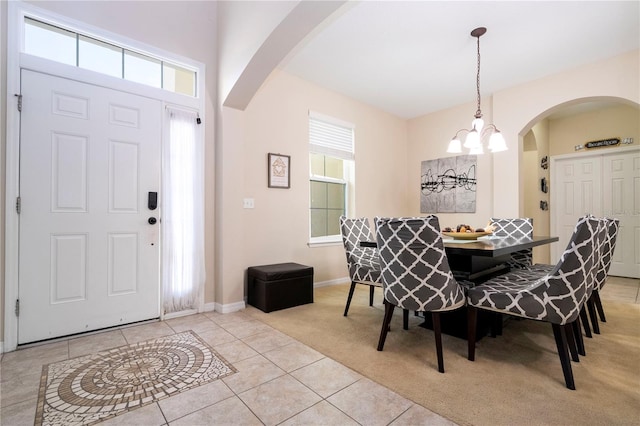 tiled dining space featuring a notable chandelier and plenty of natural light