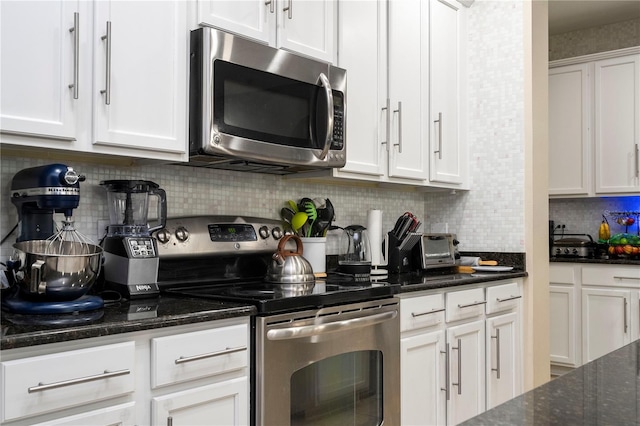 kitchen featuring white cabinets, backsplash, dark stone countertops, and appliances with stainless steel finishes