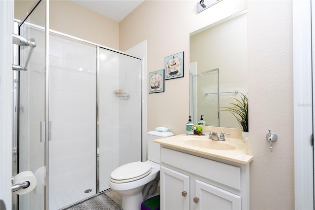 bathroom featuring an enclosed shower, vanity with extensive cabinet space, and toilet