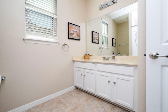 bathroom featuring tile floors, oversized vanity, and a wealth of natural light