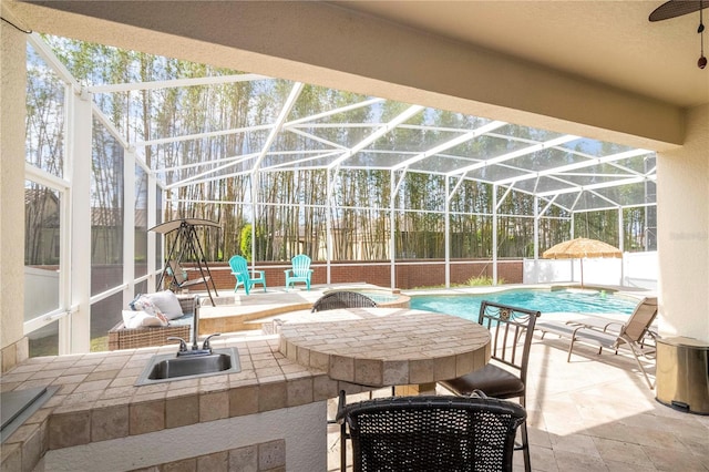 sunroom featuring ceiling fan and sink