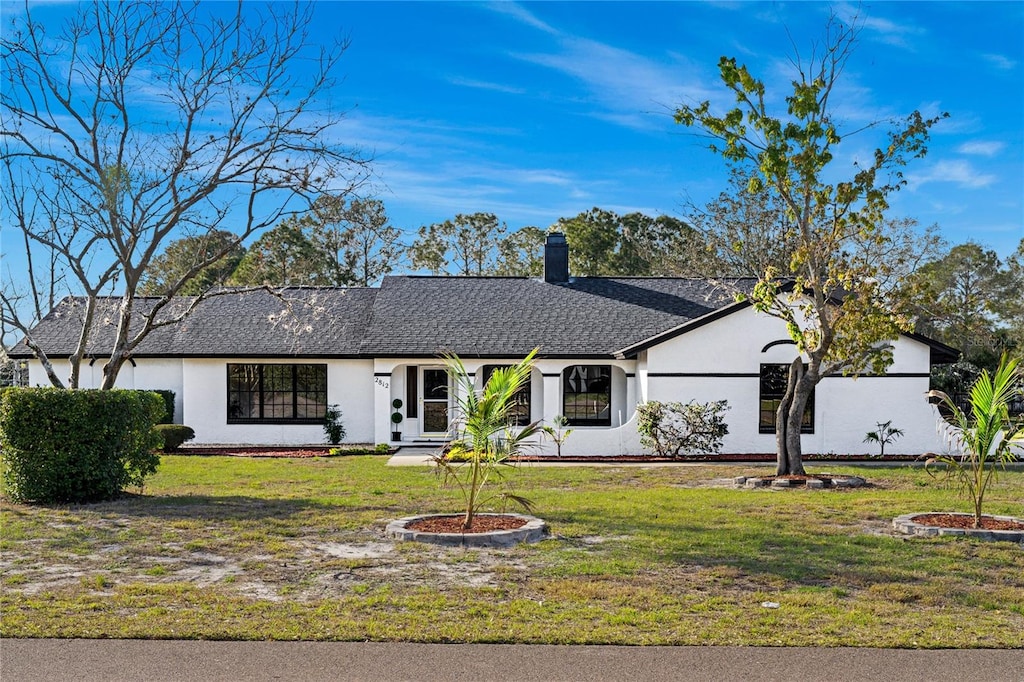 single story home featuring a front lawn