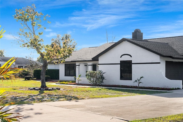 view of front facade with a front yard and a garage