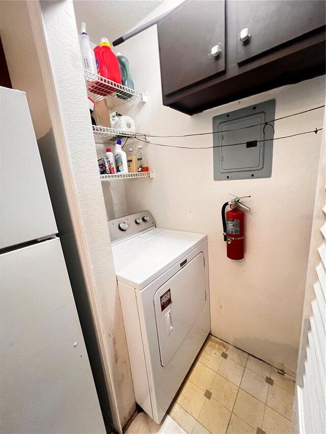 clothes washing area featuring washer / clothes dryer and cabinet space