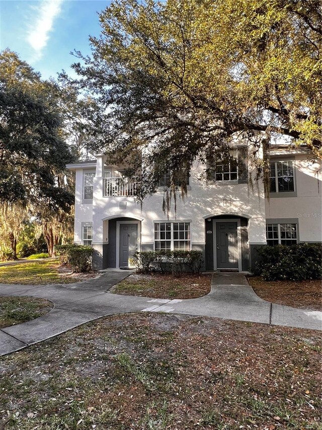 view of front of house with a balcony and stucco siding