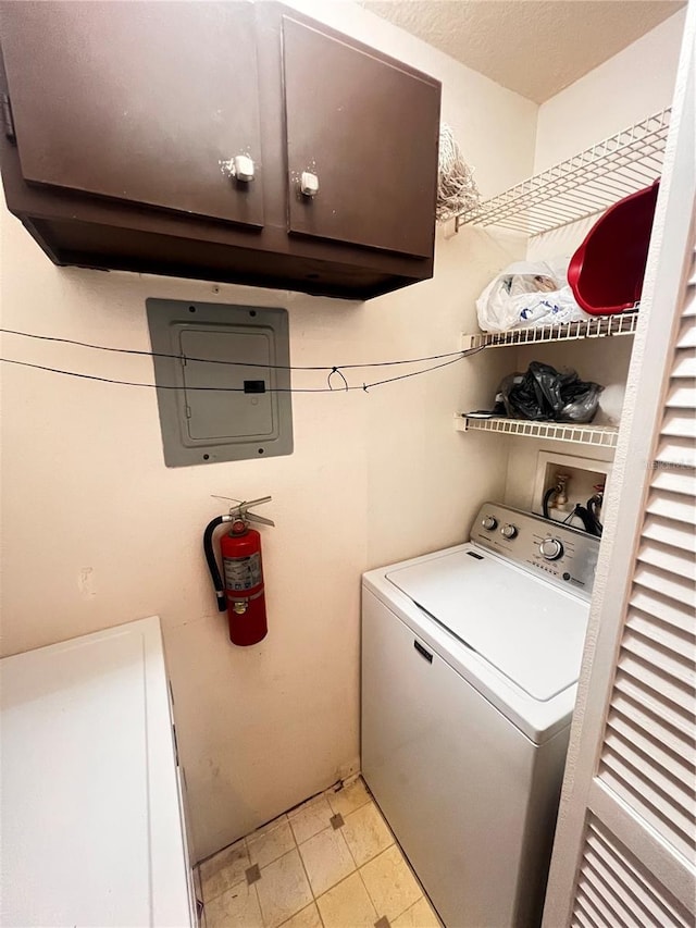 laundry area with cabinet space, a textured ceiling, and washer / clothes dryer