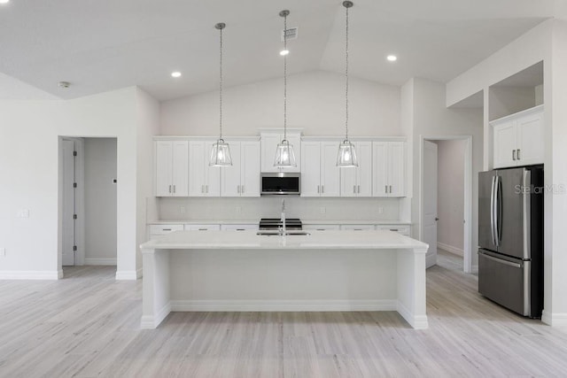 kitchen featuring white cabinetry, decorative light fixtures, a center island with sink, appliances with stainless steel finishes, and decorative backsplash