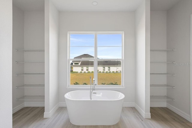 bathroom with hardwood / wood-style floors and a tub