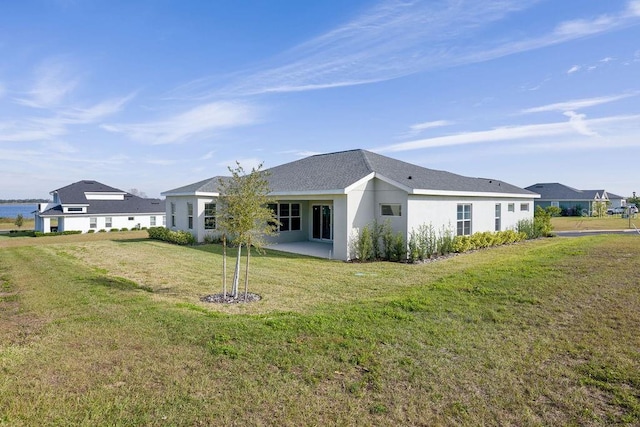 rear view of house featuring a patio and a yard