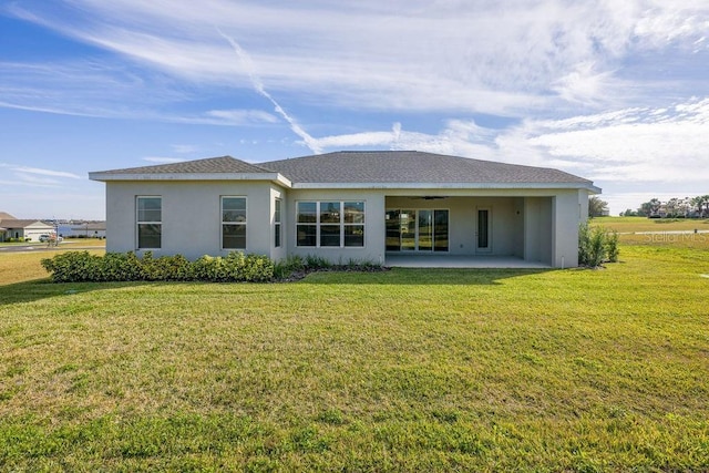 rear view of property featuring a yard and a patio area