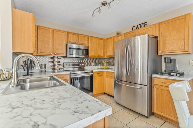 2881 Kokomo Loop, Haines City, FL 33844 - kitchen featuring stainless steel appliances, light tile flooring, a textured ceiling, backsplash, and sink