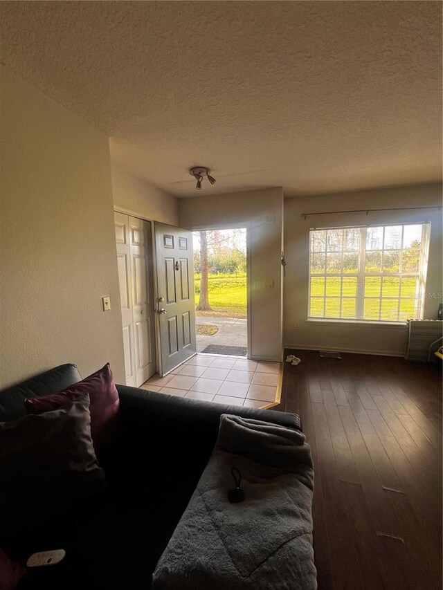 living room with a textured ceiling and light wood-type flooring