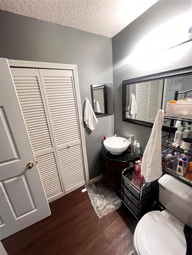 bathroom with oversized vanity, a textured ceiling, and wood-type flooring