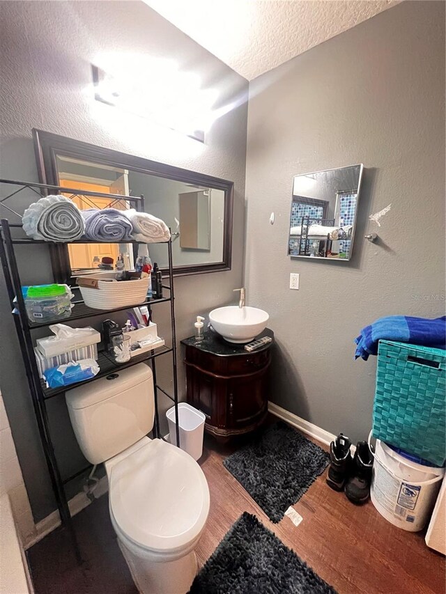 bathroom with toilet, hardwood / wood-style floors, a textured ceiling, and vanity