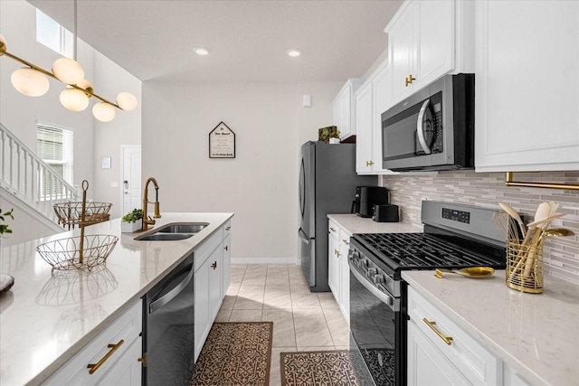 kitchen featuring sink, light tile floors, white cabinets, appliances with stainless steel finishes, and backsplash