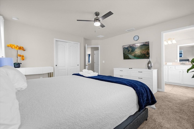 carpeted bedroom featuring ensuite bathroom, a closet, and ceiling fan