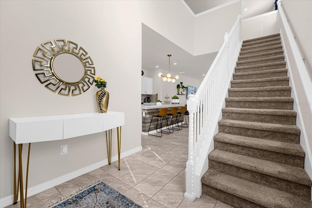 stairs with light tile floors, a notable chandelier, and a high ceiling