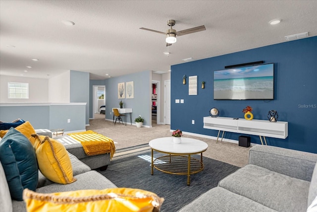 living room featuring a textured ceiling, dark carpet, and ceiling fan