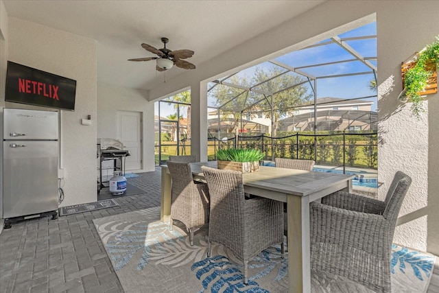 exterior space with glass enclosure and ceiling fan