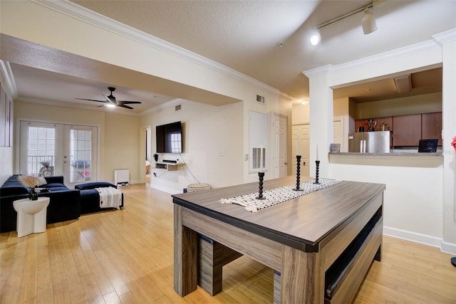 dining room featuring ceiling fan, track lighting, light wood-type flooring, french doors, and ornamental molding