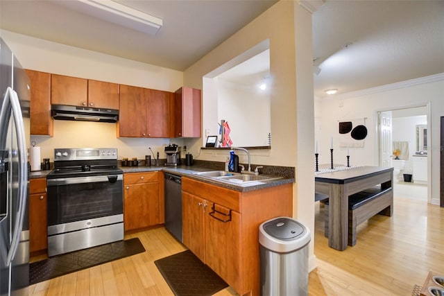 kitchen with ornamental molding, stainless steel appliances, sink, and light hardwood / wood-style flooring