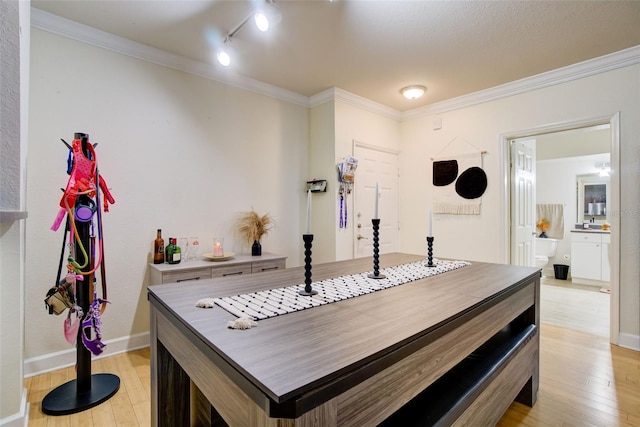 bar with crown molding, track lighting, and light hardwood / wood-style floors