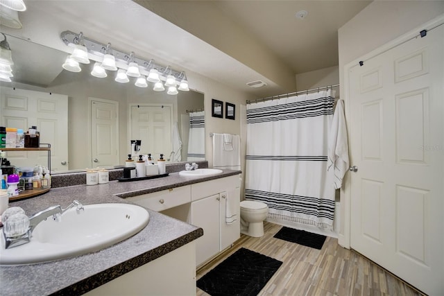 bathroom with vanity, toilet, and hardwood / wood-style floors