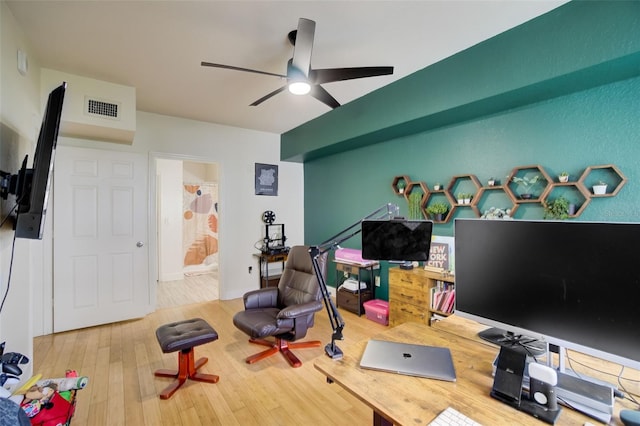 exercise room with light hardwood / wood-style floors and ceiling fan