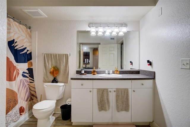 bathroom featuring toilet, large vanity, and hardwood / wood-style floors