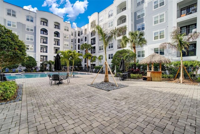 view of community with a pool, a patio, and exterior bar