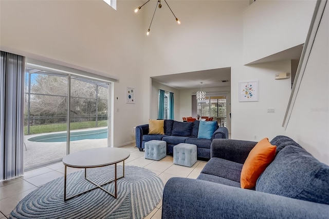 living room with light tile flooring, a notable chandelier, and a high ceiling