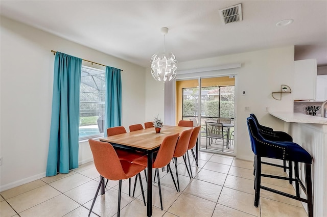 tiled dining area with a chandelier