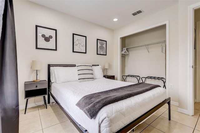 bedroom with a closet and light tile floors