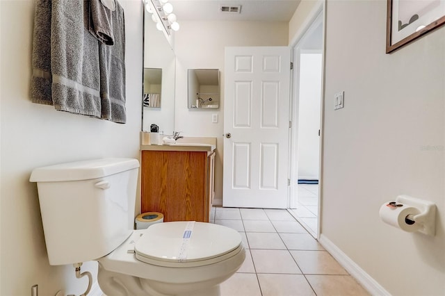 bathroom featuring tile flooring, toilet, and vanity