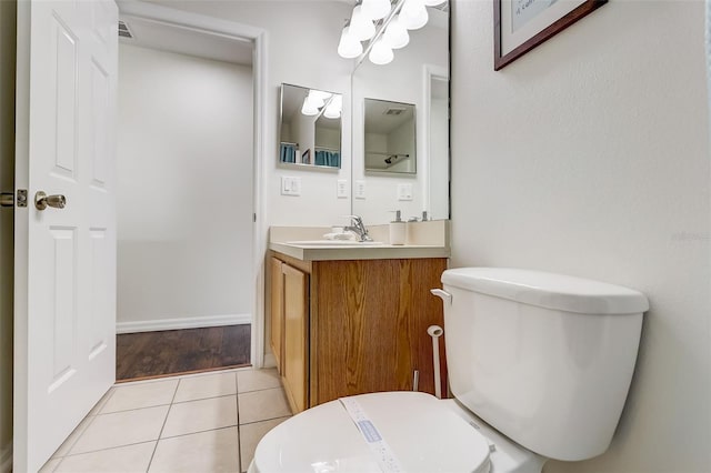 bathroom featuring toilet, tile flooring, and vanity