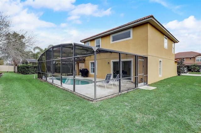 back of house featuring a lawn, a patio, and glass enclosure