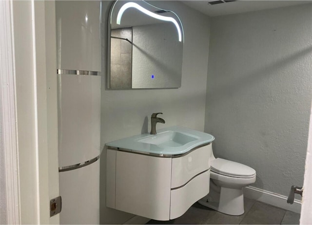 bathroom featuring toilet, tile flooring, and vanity