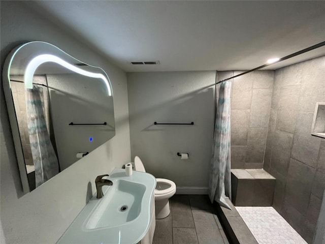 bathroom with toilet, tile flooring, curtained shower, and sink