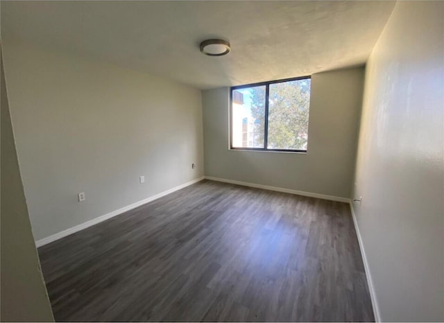 unfurnished room with dark hardwood / wood-style flooring