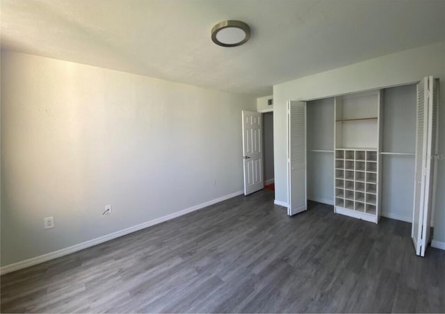 unfurnished bedroom with a closet and dark hardwood / wood-style flooring