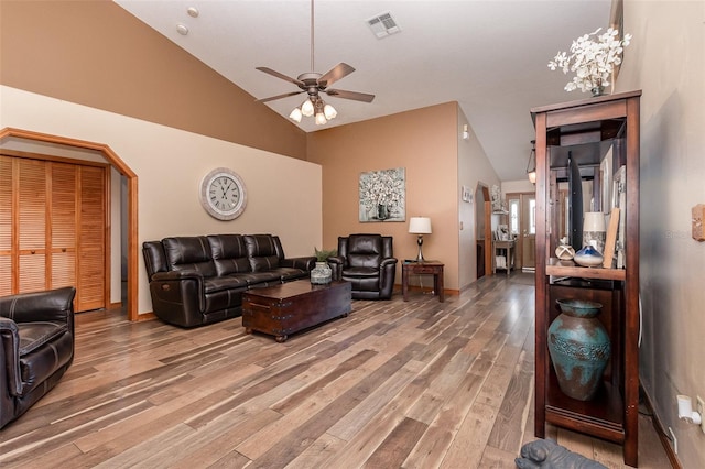 living room featuring high vaulted ceiling, ceiling fan, and light wood-type flooring