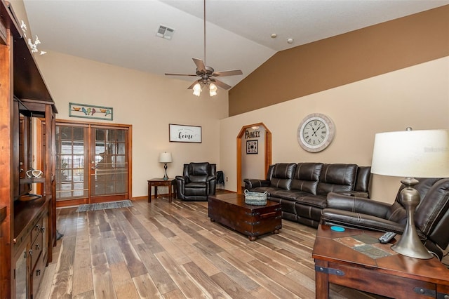 living room featuring french doors, light wood-type flooring, ceiling fan, and lofted ceiling