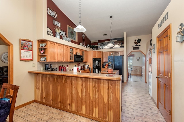 kitchen featuring light tile floors, decorative light fixtures, vaulted ceiling, kitchen peninsula, and black appliances