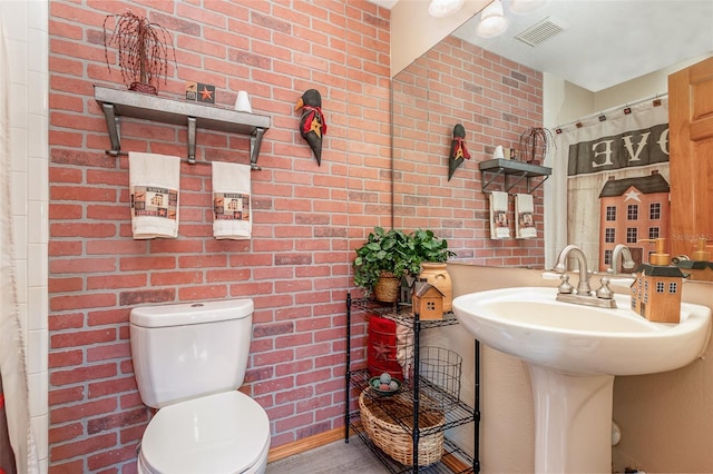 bathroom with brick wall